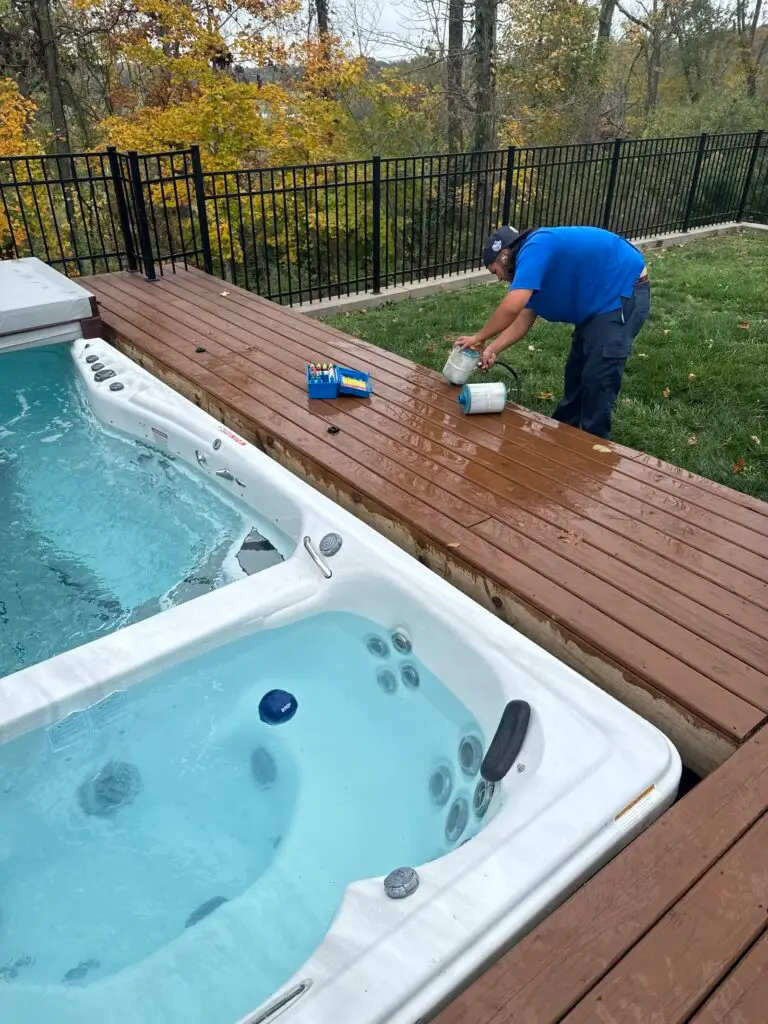 Technician maintaining a swim spa on a deck