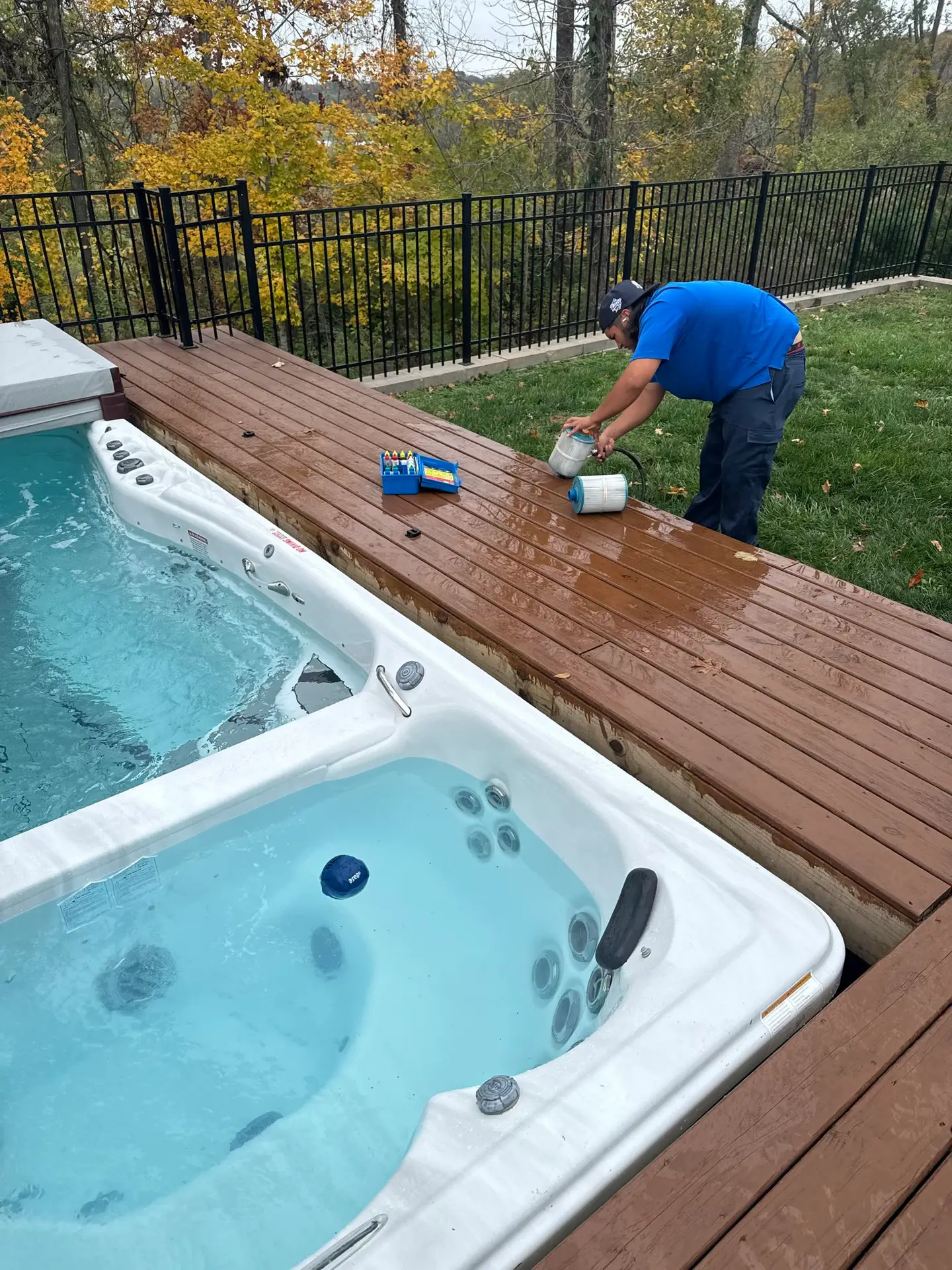 Technician maintaining a swim spa on a deck
